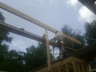 Carpenter setting a ridge beam over a new addition frame — Ice Dam Removal by Roofing Brothers in Apache