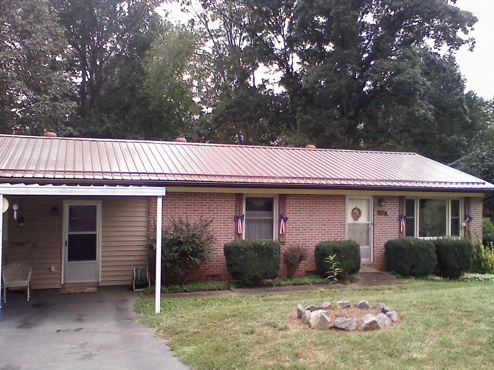Bronze metal roof and carport on a brick ranch home — Roof Repair work by our crew in Apache