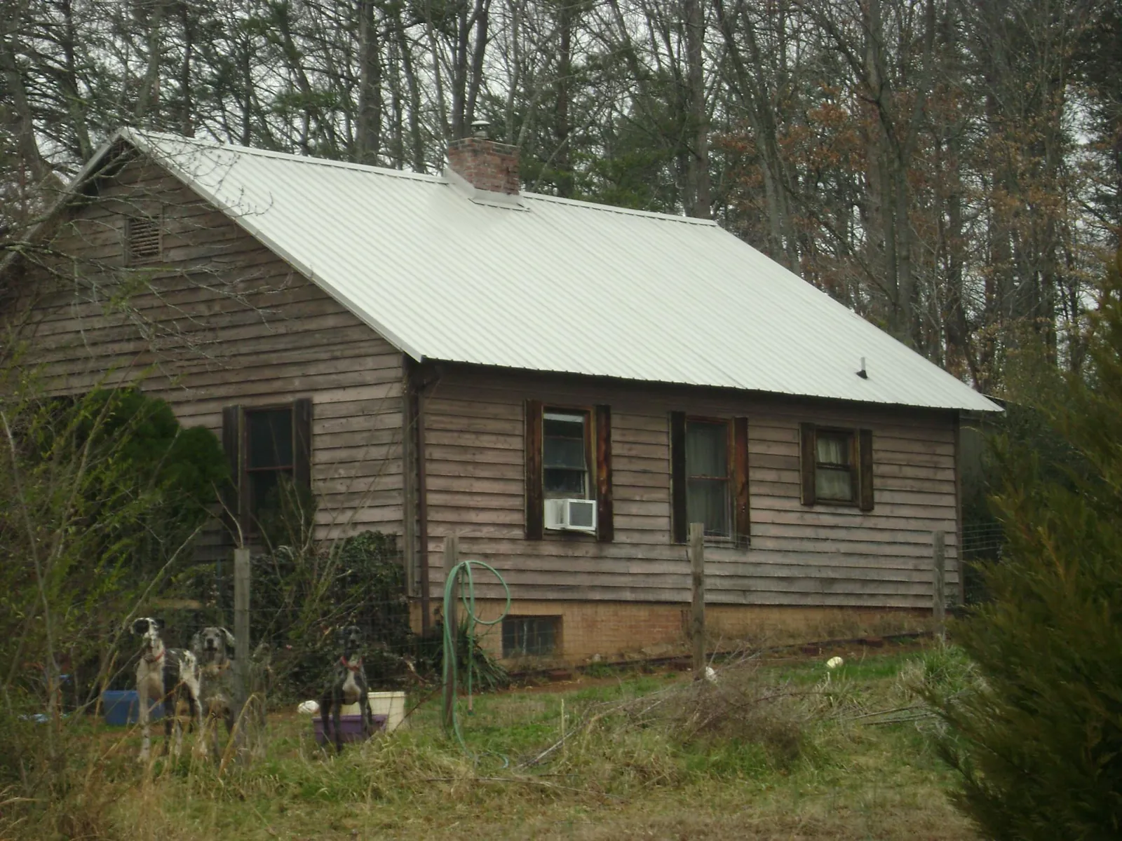 White metal roof on an old wood sided farmhouse, from a Metal Roof Installation job in Apache